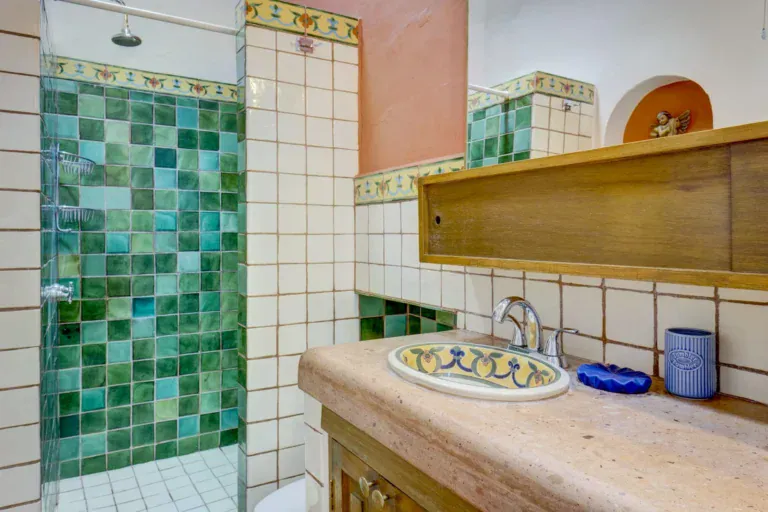 Casa Firenze, bathroom with a green tile shower, a hand-painted sink and a peach wall, San Miguel de Allende