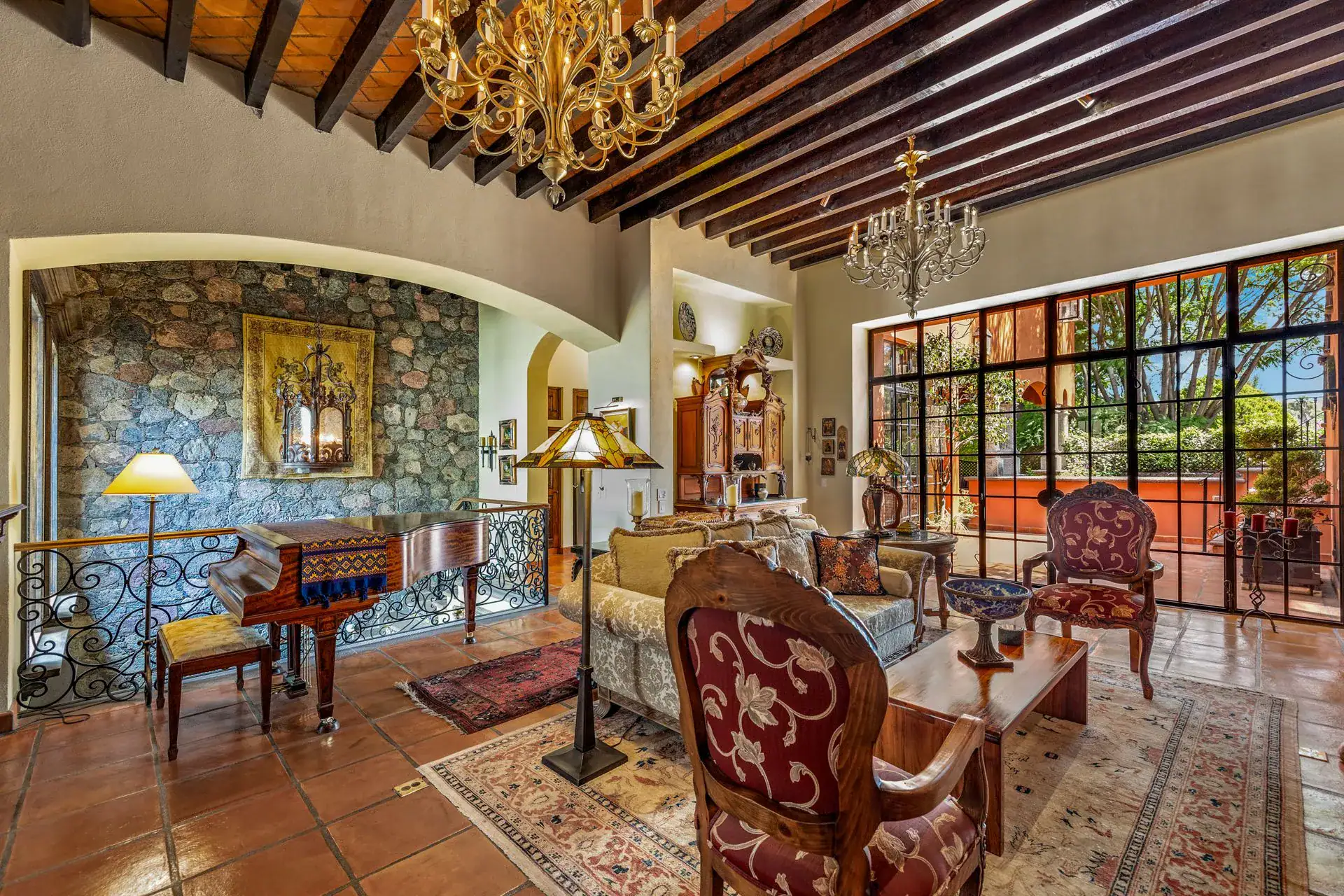 Casa Flora, living room with a grand piano, a stone alcove and a steel-framed glass wall to the terrace, San Miguel de Allende