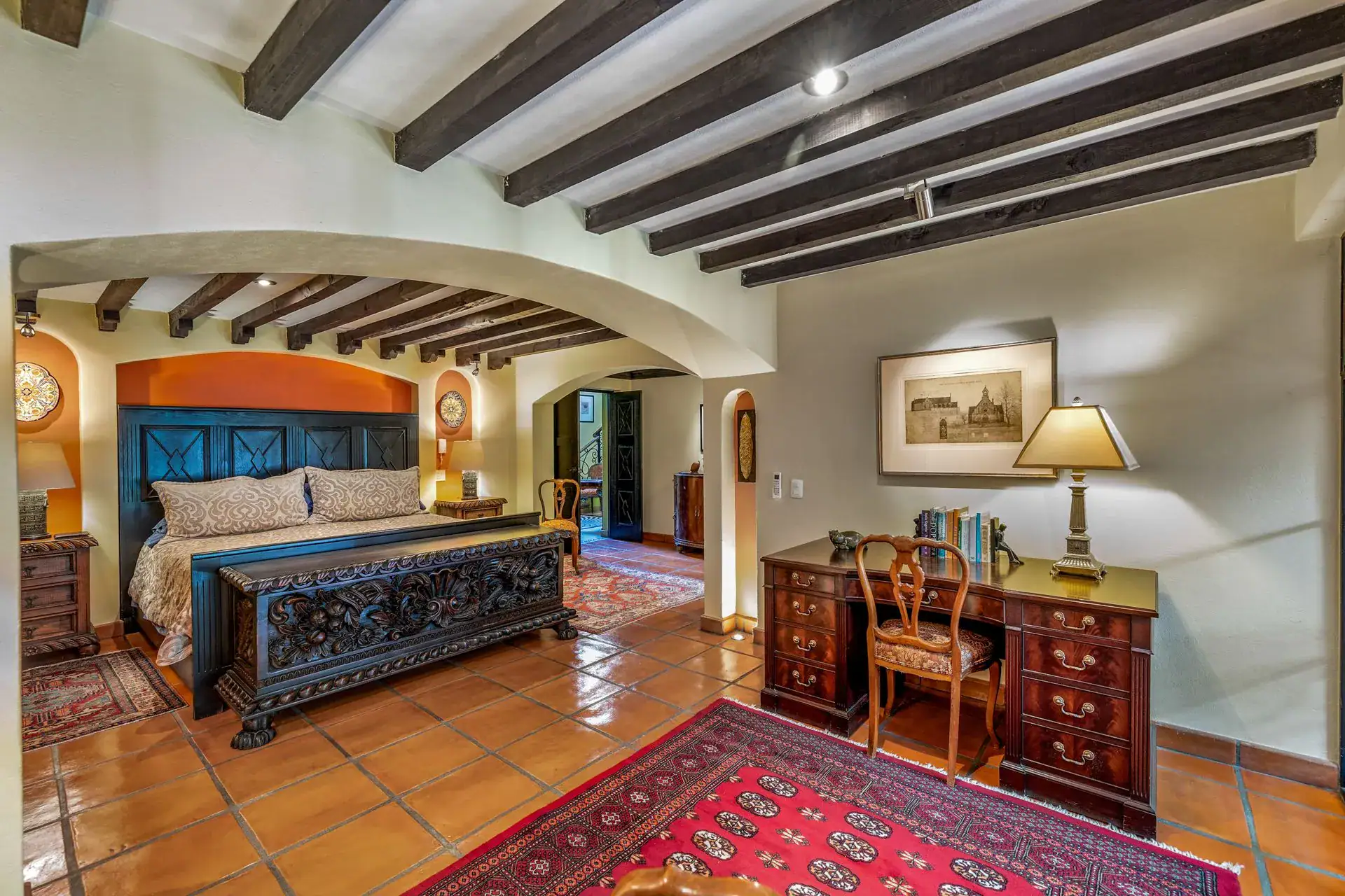 Casa Flora, bedroom with a blue carved headboard, a desk and a view into the garden, San Miguel de Allende