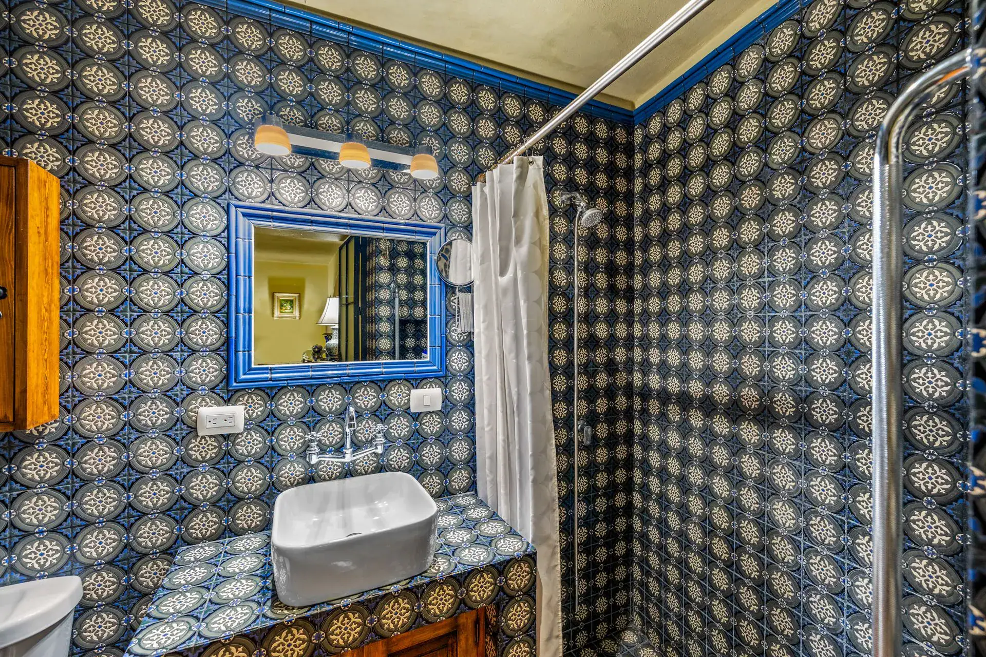 Casa Flora, bathroom with blue and white tile, a white vessel sink and a shower curtain, San Miguel de Allende