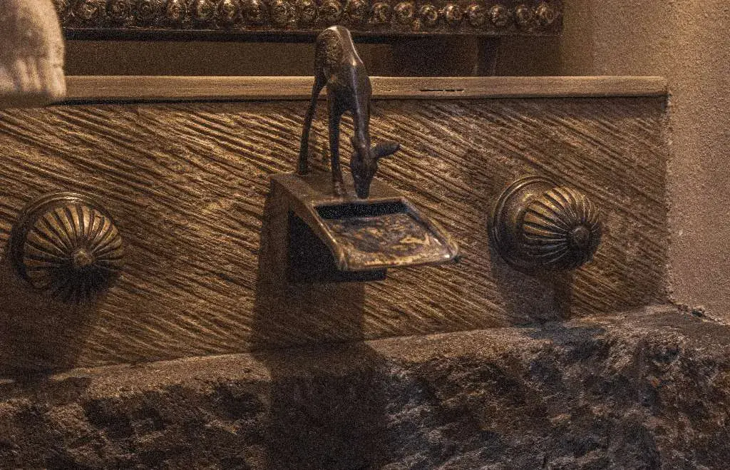 Casa Garza, stone wall fountain with a bronze animal figure spout and two brass medallions, San Miguel de Allende
