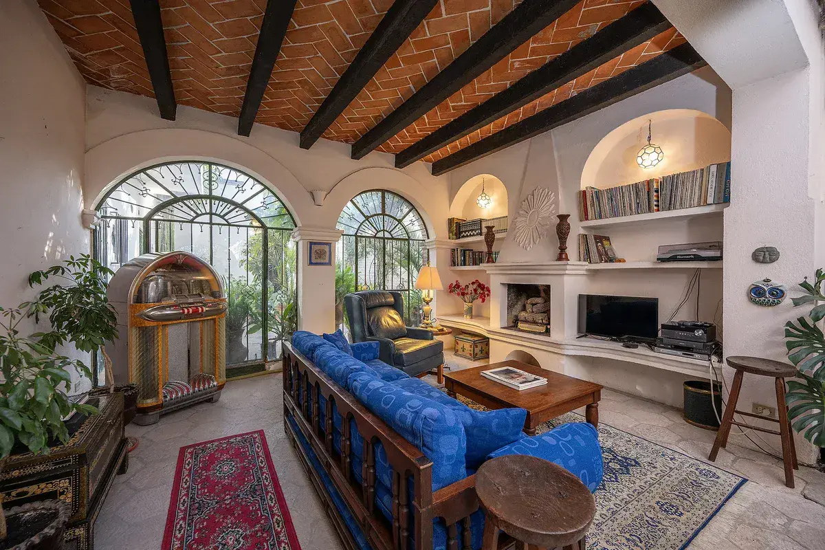 Casa Gracia, den with a blue sofa, a jukebox and arched windows under a beamed ceiling, San Miguel de Allende