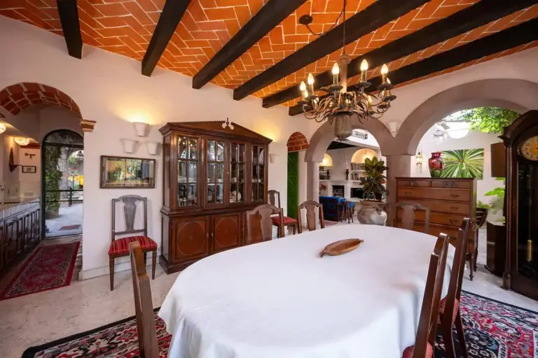 Casa Gracia, dining room with a white tablecloth, a china cabinet and a brick vaulted ceiling, San Miguel de Allende