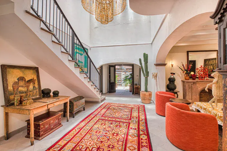 Casa Grillo, entry hall with a staircase, a wood console and a red runner, San Miguel de Allende