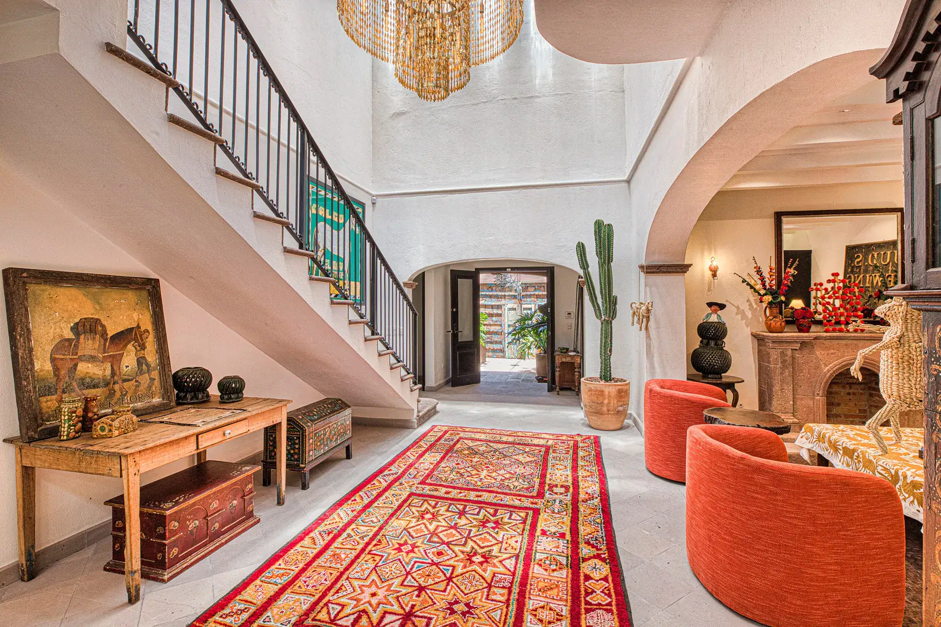Casa Grillo, entry hall with a staircase, a wood console and a red runner, San Miguel de Allende