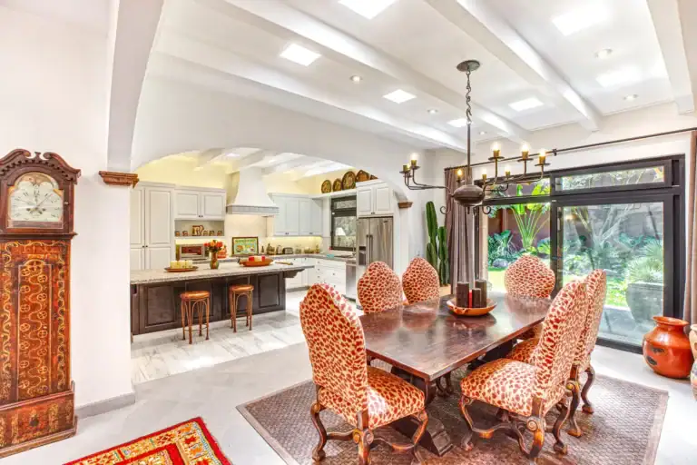 Casa Grillo, dining room with leopard-print chairs, a long wood table and a pendant light, San Miguel de Allende