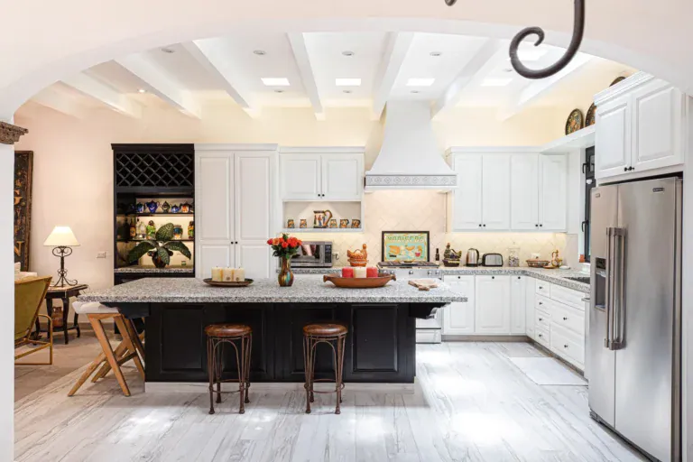 Casa Grillo, kitchen with white cabinets, a black island and a granite counter, San Miguel de Allende