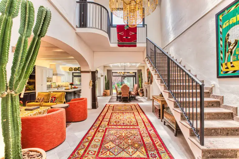 Casa Grillo, living area and staircase with cactus in the foreground and a chandelier, San Miguel de Allende