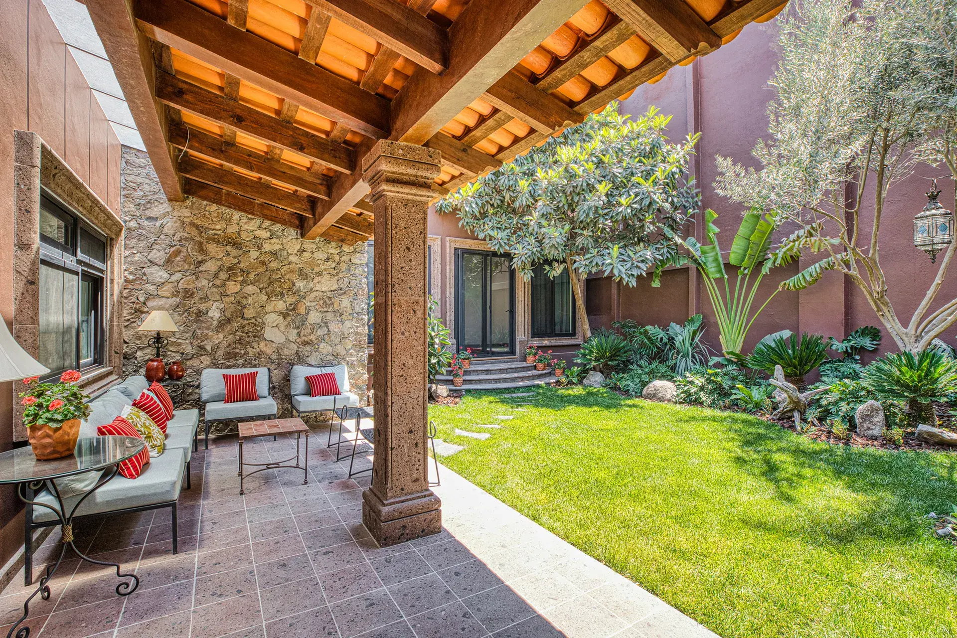 Casa Grillo, garden loggia with seating and a lawn between stone columns, San Miguel de Allende