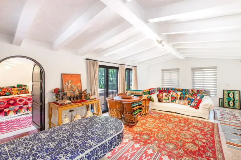 Casa Grillo, upstairs living room with colorful textiles and a red rug, San Miguel de Allende