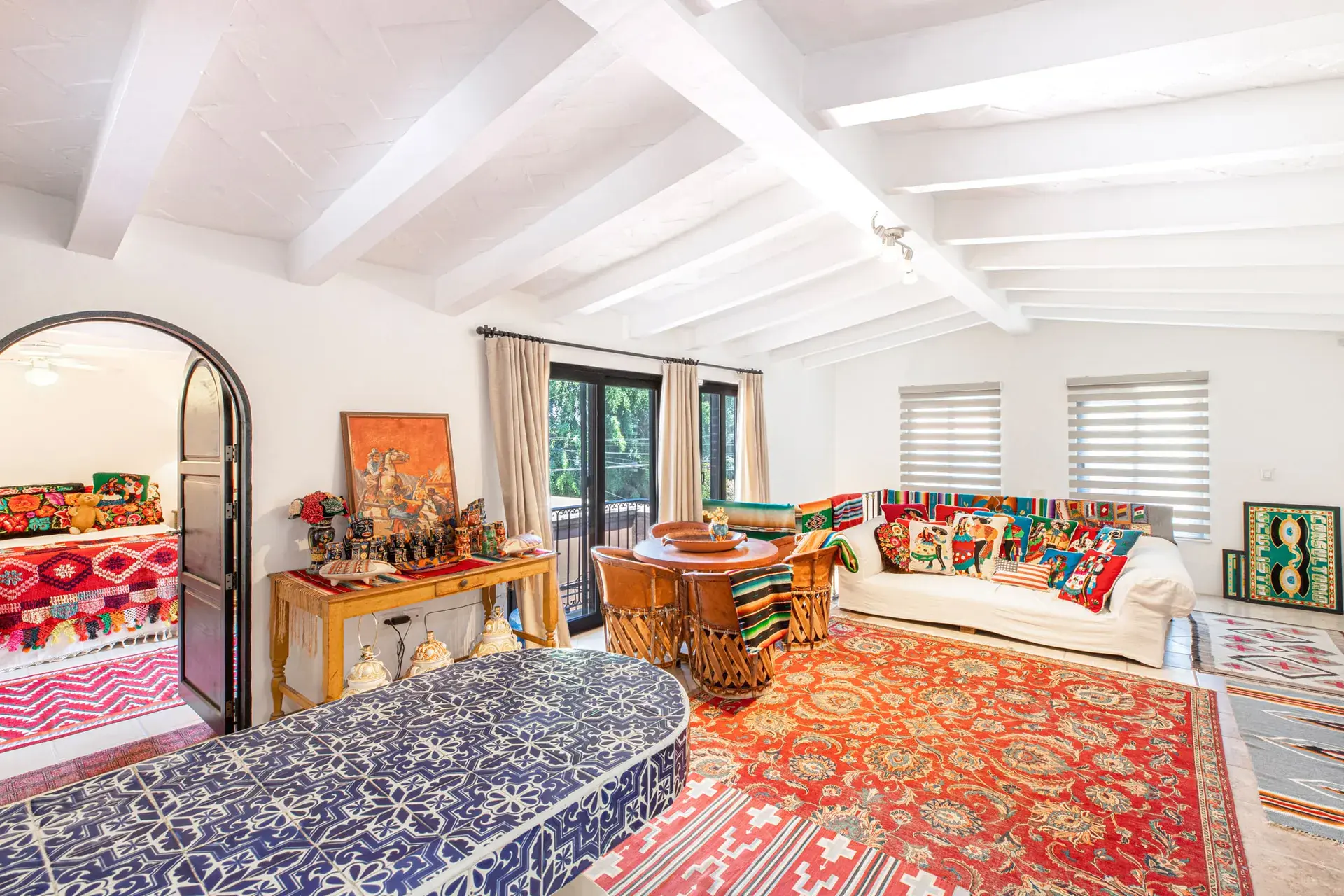 Casa Grillo, upstairs living room with colorful textiles and a red rug, San Miguel de Allende
