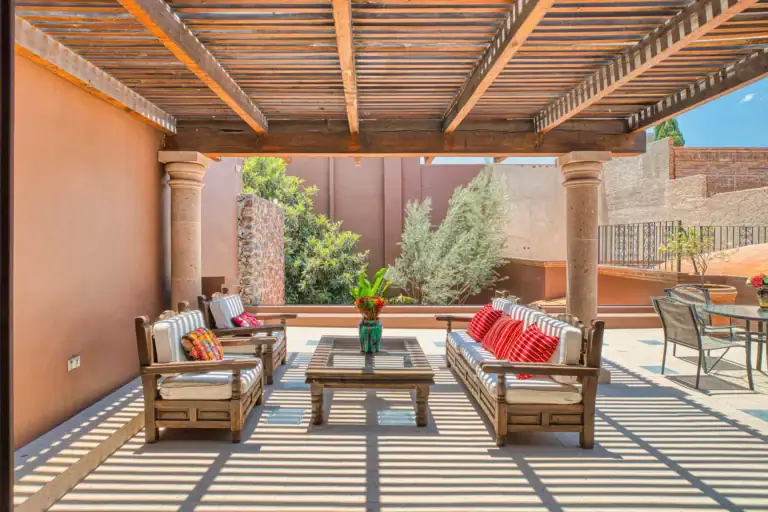 Casa Grillo, terrace with outdoor sofas on a gray tile floor under a pergola, San Miguel de Allende