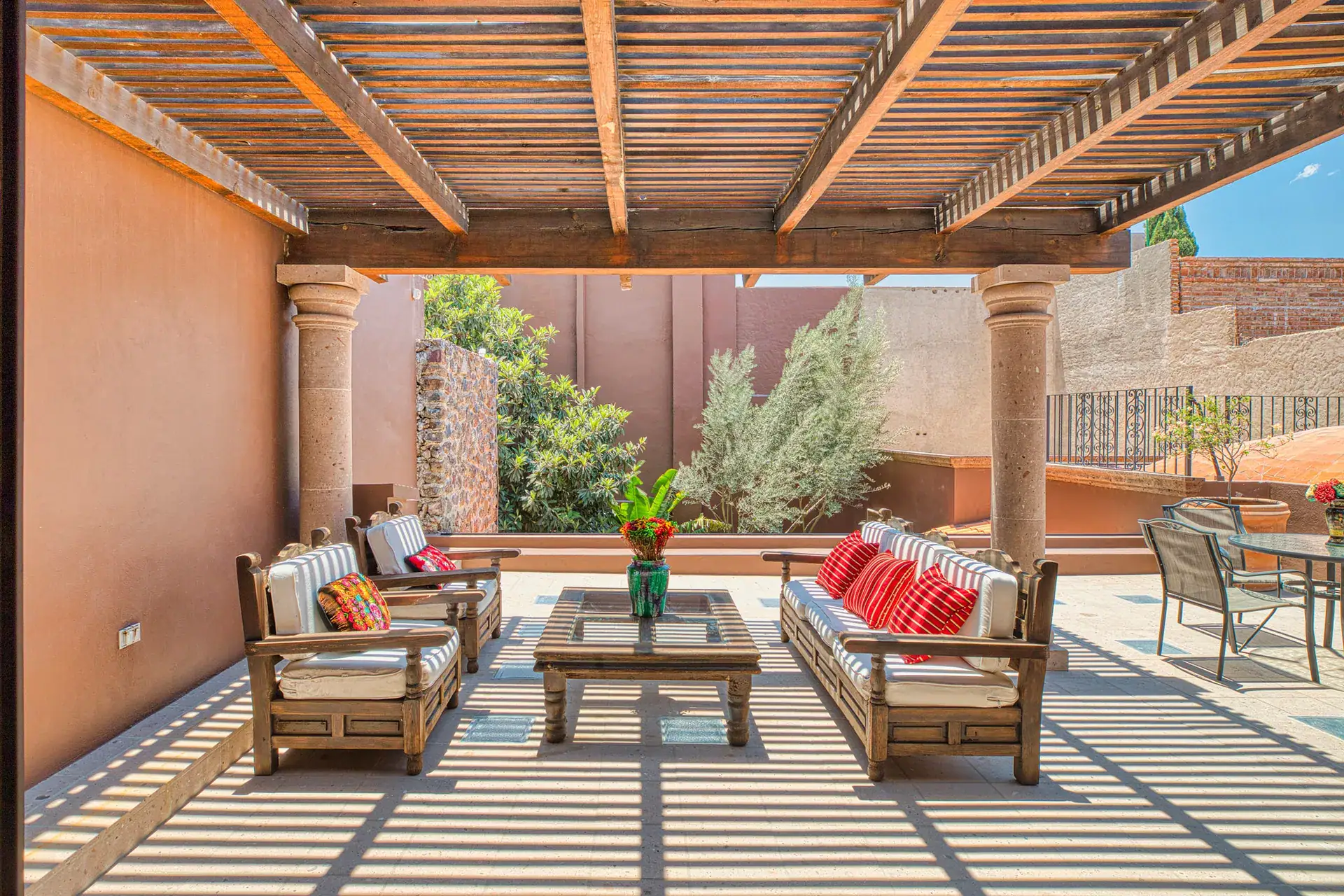 Casa Grillo, terrace with outdoor sofas on a gray tile floor under a pergola, San Miguel de Allende