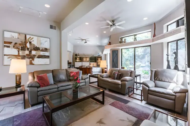 Casa Guadiana, living room with brown leather sofas, a glass coffee table and a high ceiling with fans, San Miguel de Allende