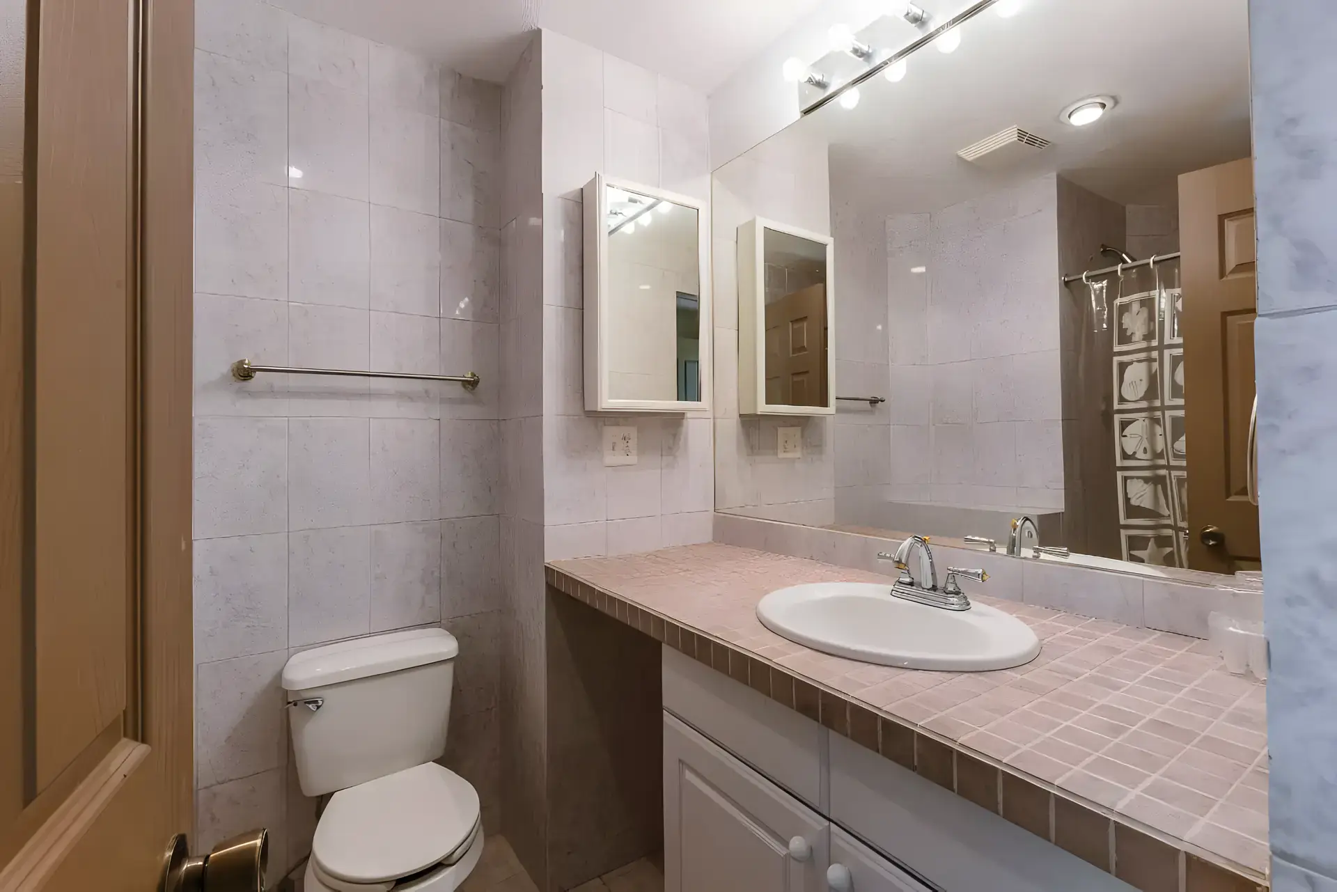 Casa Guadiana, guest bathroom with a tiled vanity, toilet and a shower curtain, San Miguel de Allende