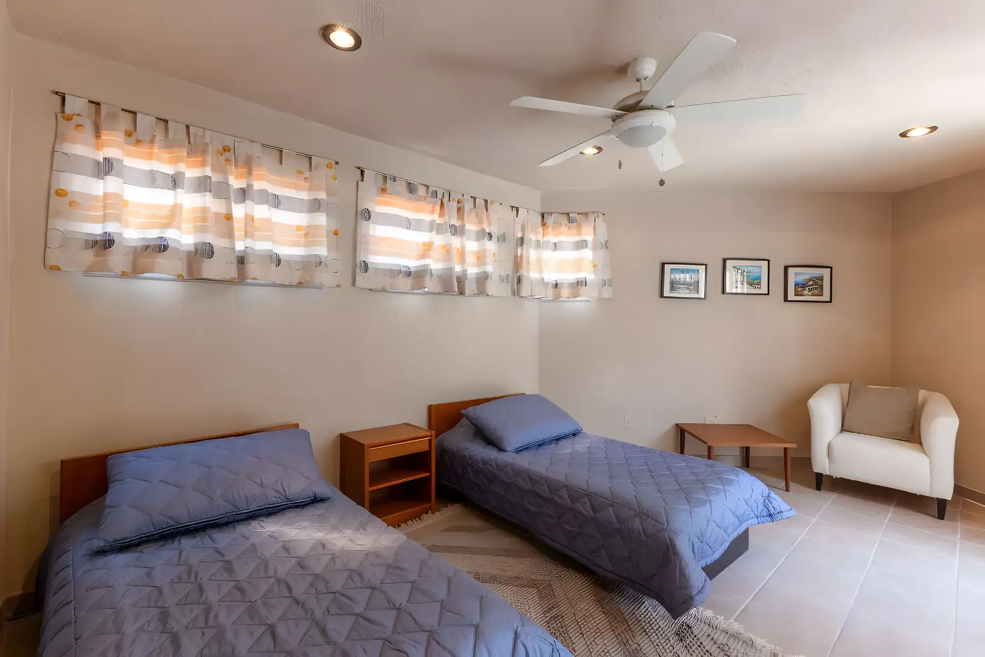 Casa Guadiana, bedroom with two single beds with blue quilts and striped curtains, San Miguel de Allende