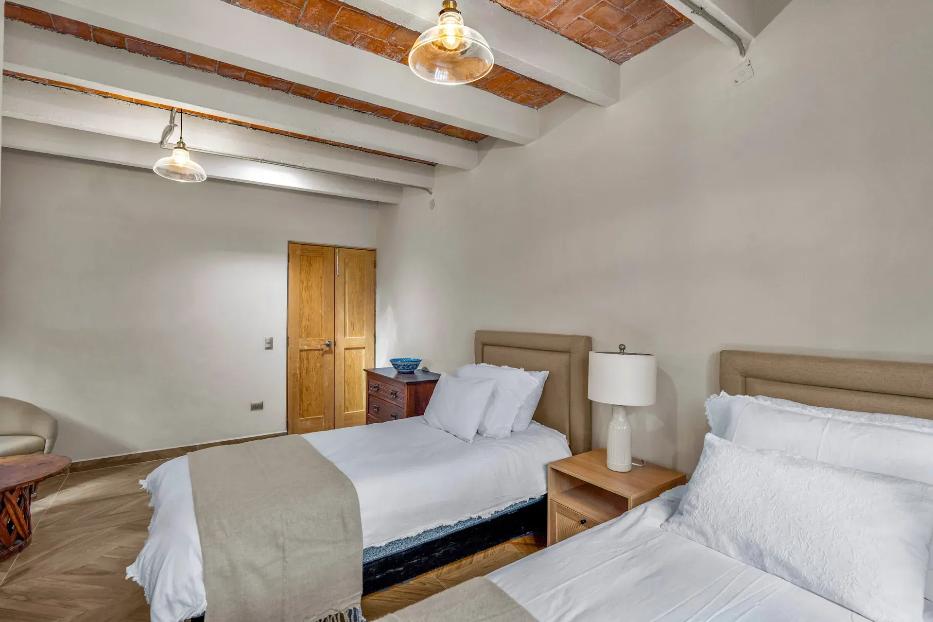 Casa Hidalgo, bedroom with two beds with white bedding, a nightstand lamp and a brick vaulted ceiling, San Miguel de Allende