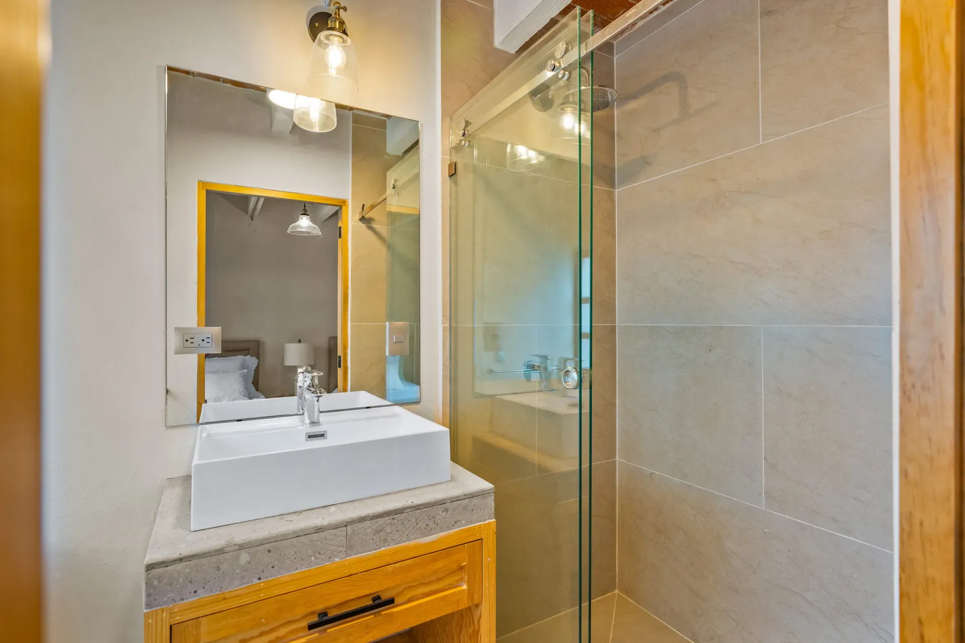 Casa Hidalgo, bathroom with a white vessel sink on a wood vanity, a wall mirror and a glass shower, San Miguel de Allende