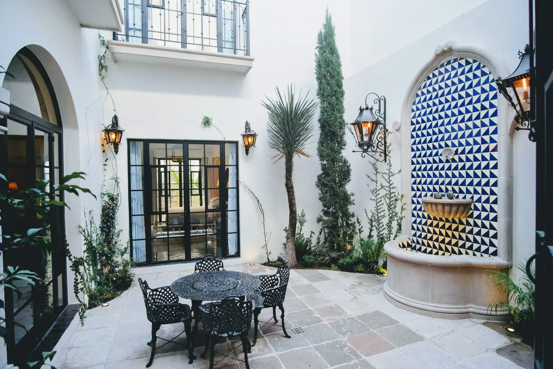 Casa Jacaranda, courtyard with a blue and white tile fountain and a cast-iron table, San Miguel de Allende