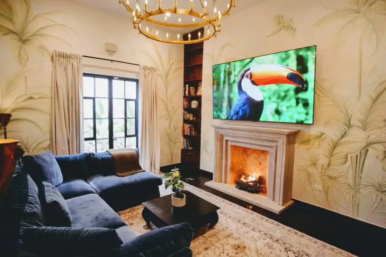 Casa Jacaranda, living room with a fireplace, a mural wall and a gold ring chandelier, San Miguel de Allende
