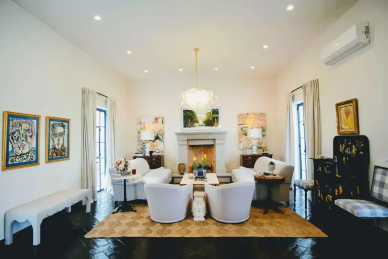 Casa Jacaranda, sitting room with white armchairs, a fireplace and a dark herringbone floor, San Miguel de Allende