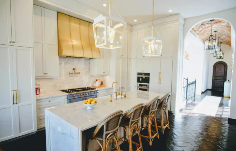 Casa Jacaranda, kitchen with a marble island, brass hood and white cabinets, San Miguel de Allende