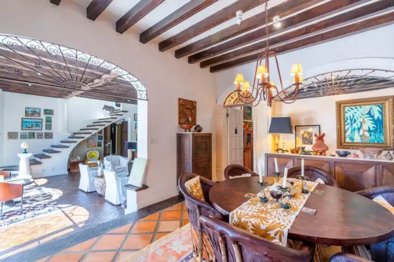 Casa Jardín, dining room with an oval wood table and a wrought-iron chandelier, San Miguel de Allende