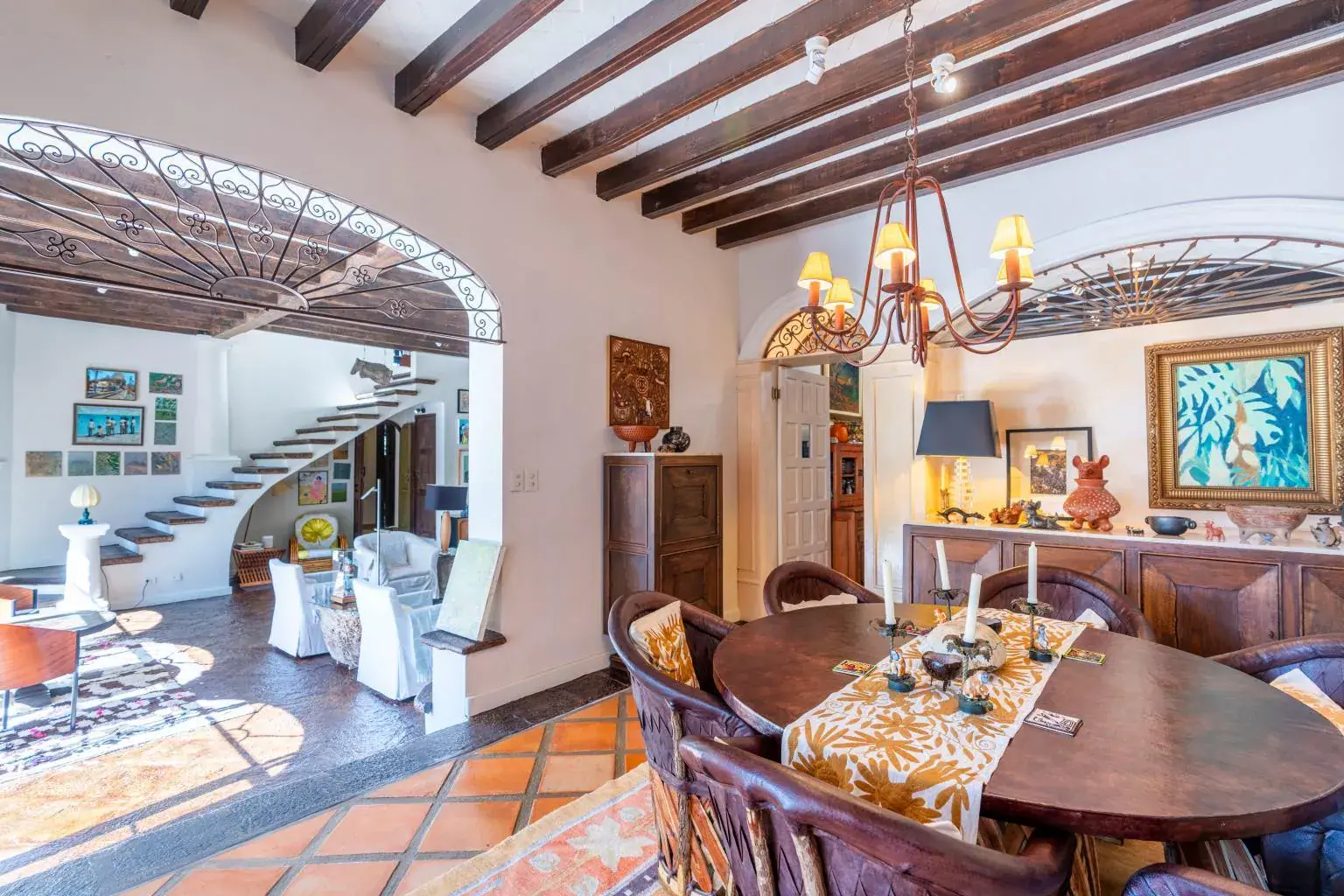 Casa Jardín, dining room with an oval wood table and a wrought-iron chandelier, San Miguel de Allende