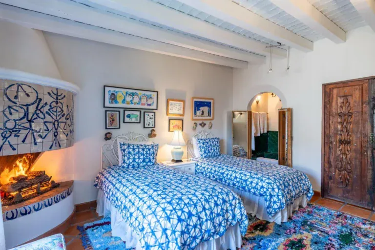 Casa Jardín, bedroom with a fireplace, twin beds and blue patterned bedding, San Miguel de Allende