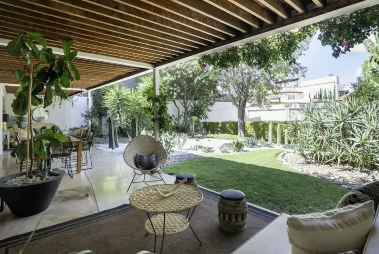 Casa Juan Guadiana, covered loggia with a slatted wood ceiling opening to the lawn, San Miguel de Allende