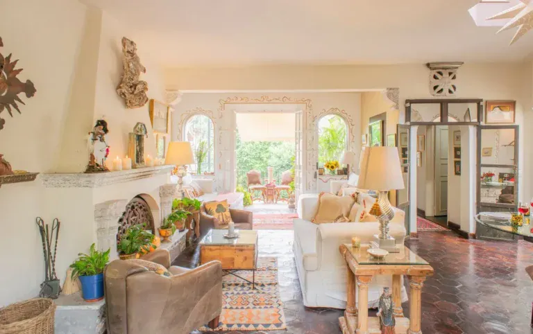 Casa Kate, living room with a fireplace and white sofas opening to a terrace, San Miguel de Allende