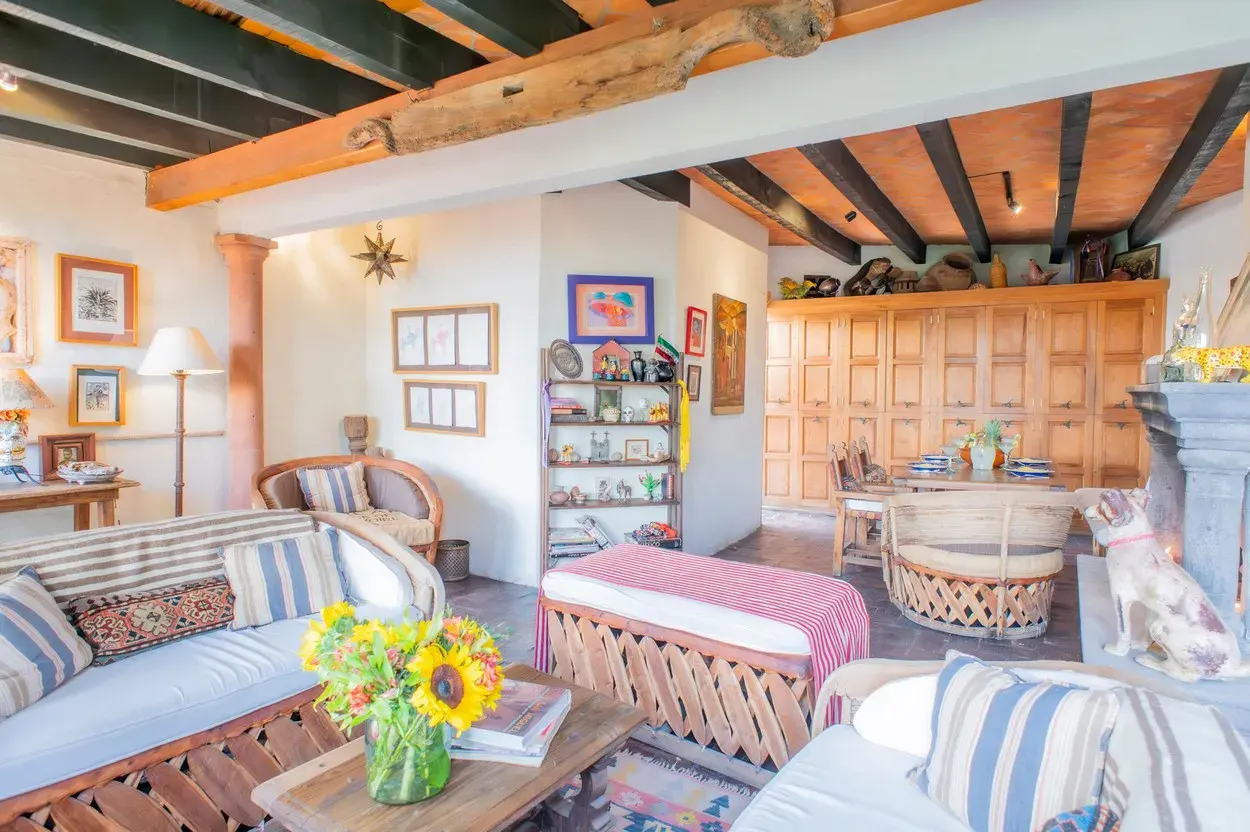 Casa Kate, sitting room with striped sofas, a fireplace and a wood beam ceiling, San Miguel de Allende