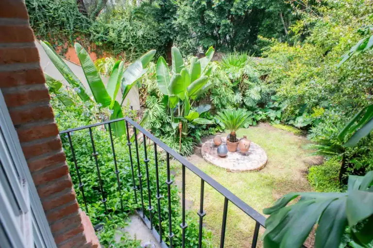Casa Kate, garden view from a balcony over a lawn with a stone circle, San Miguel de Allende