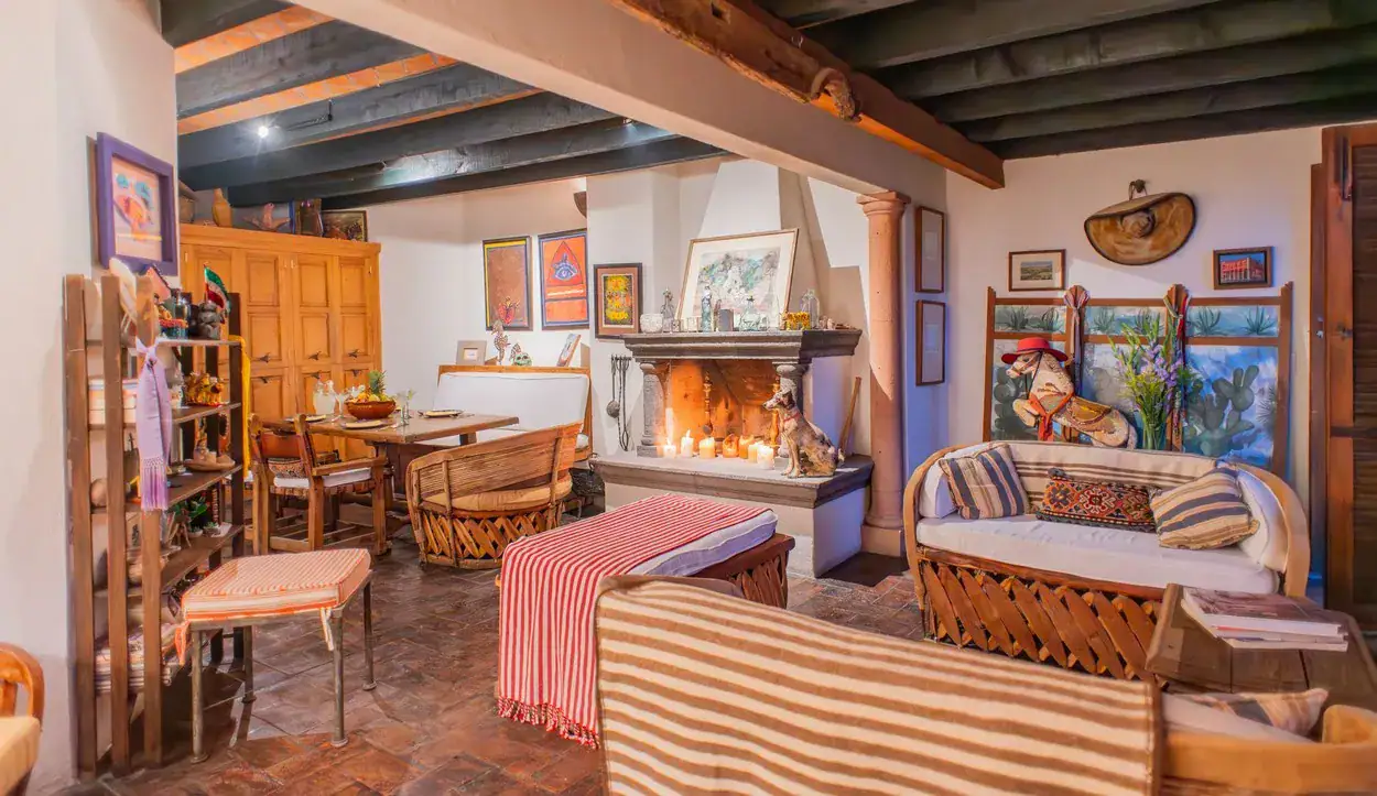 Casa Kate, covered terrace lounge with a fireplace and striped cushions, San Miguel de Allende