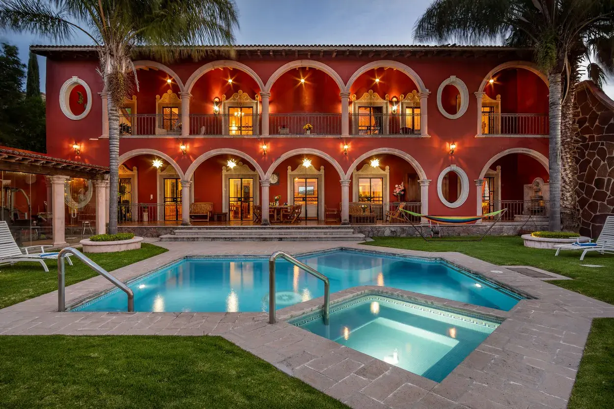 Casa La Colina, two-story arcaded facade glowing above the pool, San Miguel de Allende