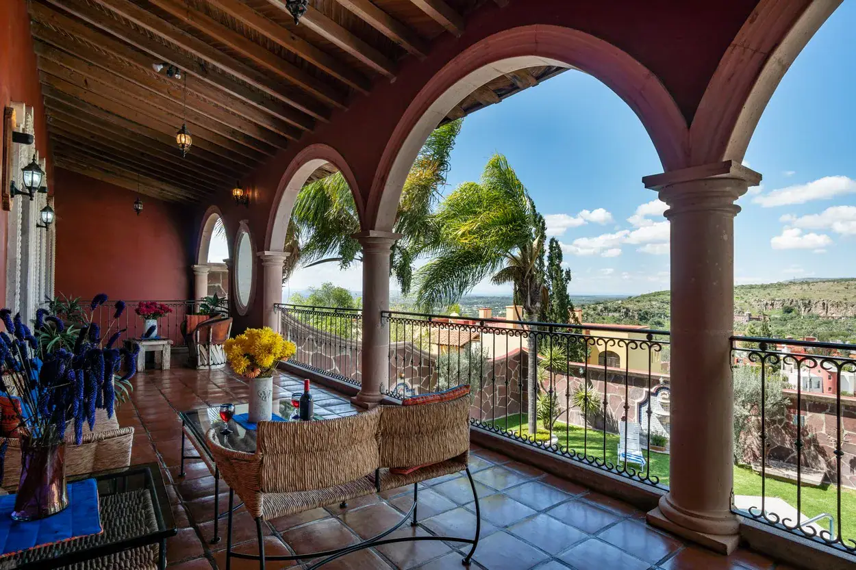 Casa La Colina, covered loggia with a table and arches framing the valley view, San Miguel de Allende