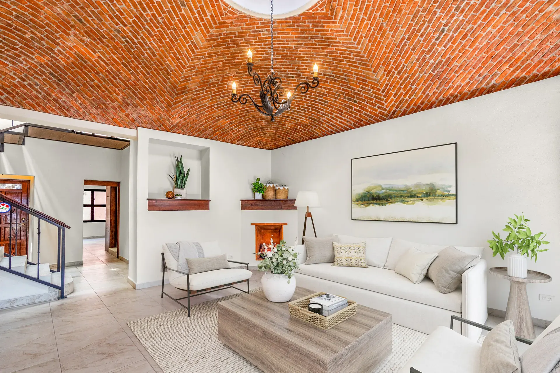 Casa Las Monjas, living room with a brick vaulted ceiling, a skylight, a white sofa and a corner fireplace (virtually staged), San Miguel de Allende