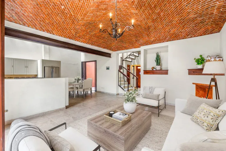Casa Las Monjas, open living and kitchen area with a dining table and a steel stair in the background (virtually staged), San Miguel de Allende