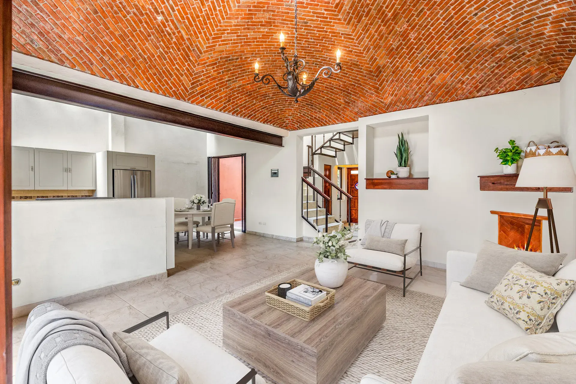 Casa Las Monjas, open living and kitchen area with a dining table and a steel stair in the background (virtually staged), San Miguel de Allende