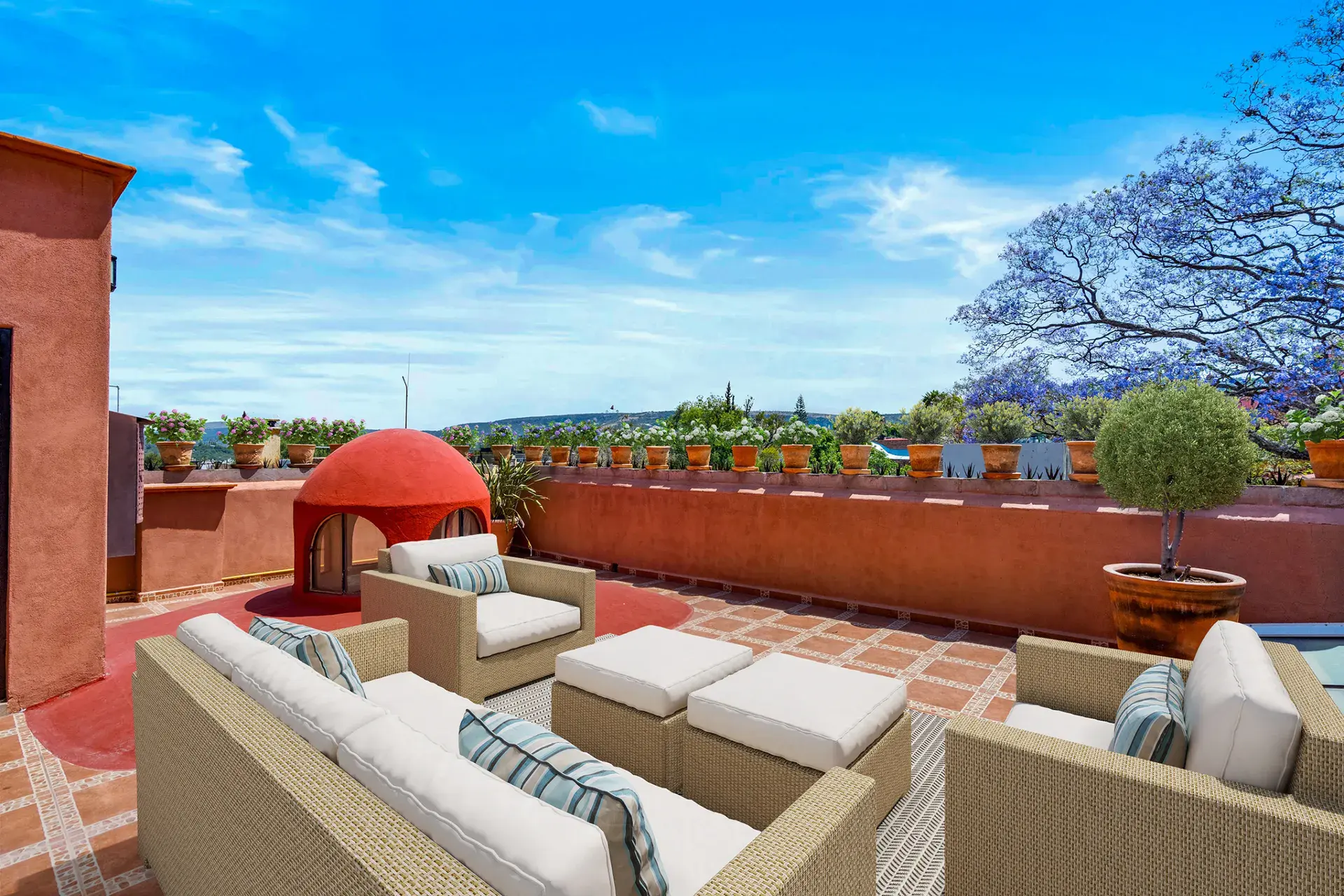 Casa Las Monjas, rooftop terrace with wicker seating, a red dome and a long terracotta wall (virtually staged), San Miguel de Allende