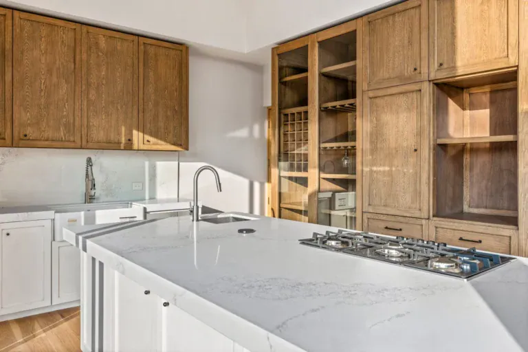 Casa Lavanda, kitchen counter with a white island, a gas cooktop and tall wood cabinets and shelves, San Miguel de Allende