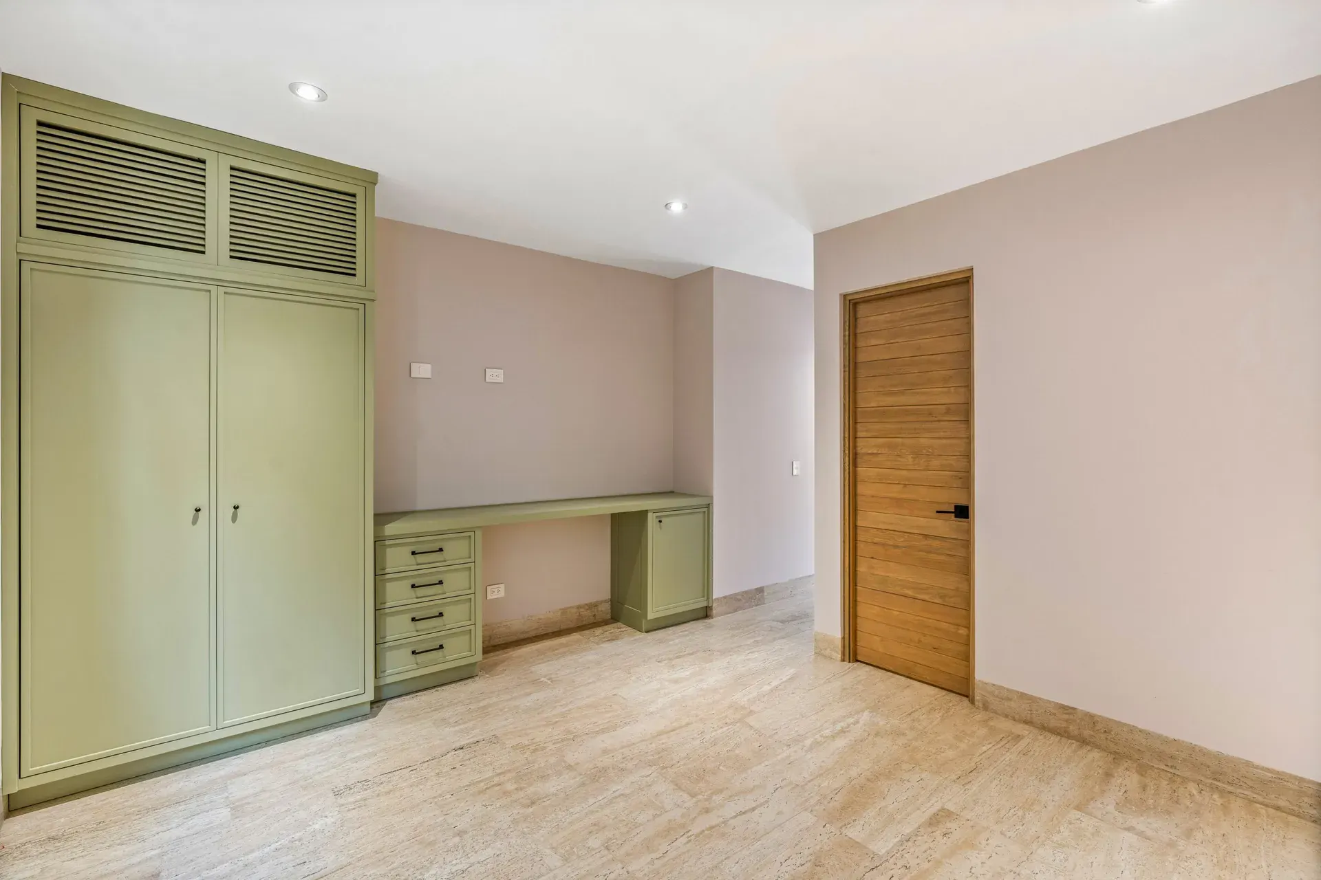 Casa Lavanda, bedroom with a green built-in wardrobe and desk, a wood door and light floors, San Miguel de Allende
