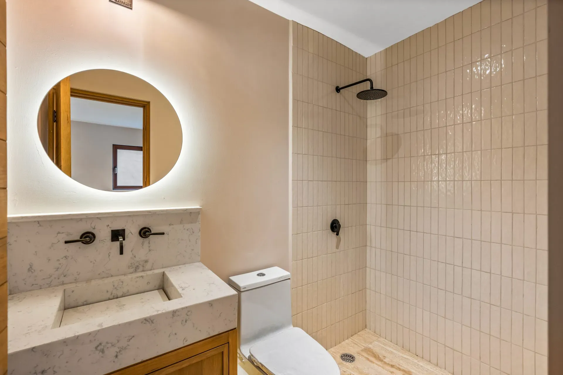 Casa Lavanda, bathroom with a round backlit mirror, a stone trough sink and a tiled shower, San Miguel de Allende