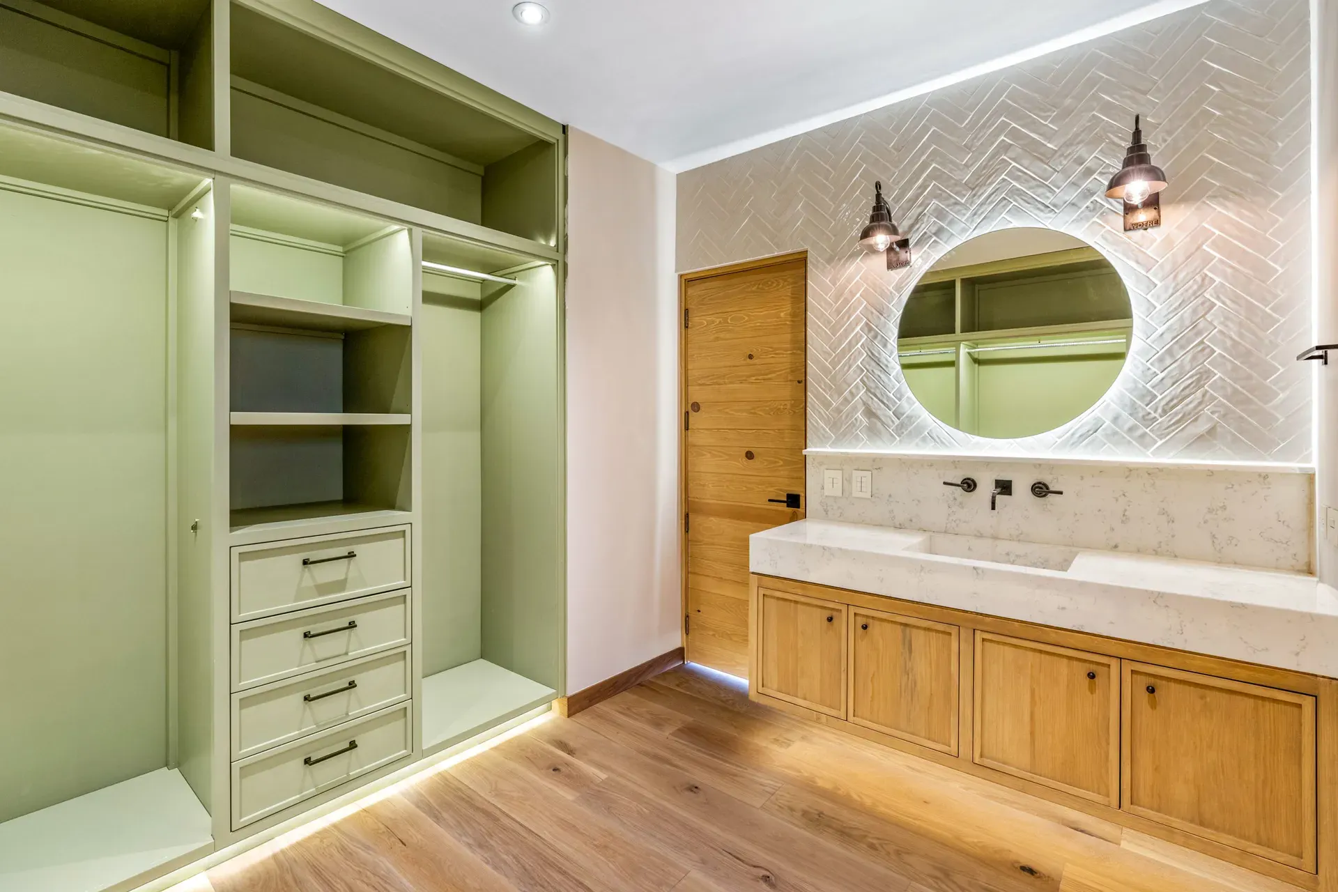 Casa Lavanda, walk-in dressing room with sage green built-in shelves and drawers beside a bathroom vanity, San Miguel de Allende