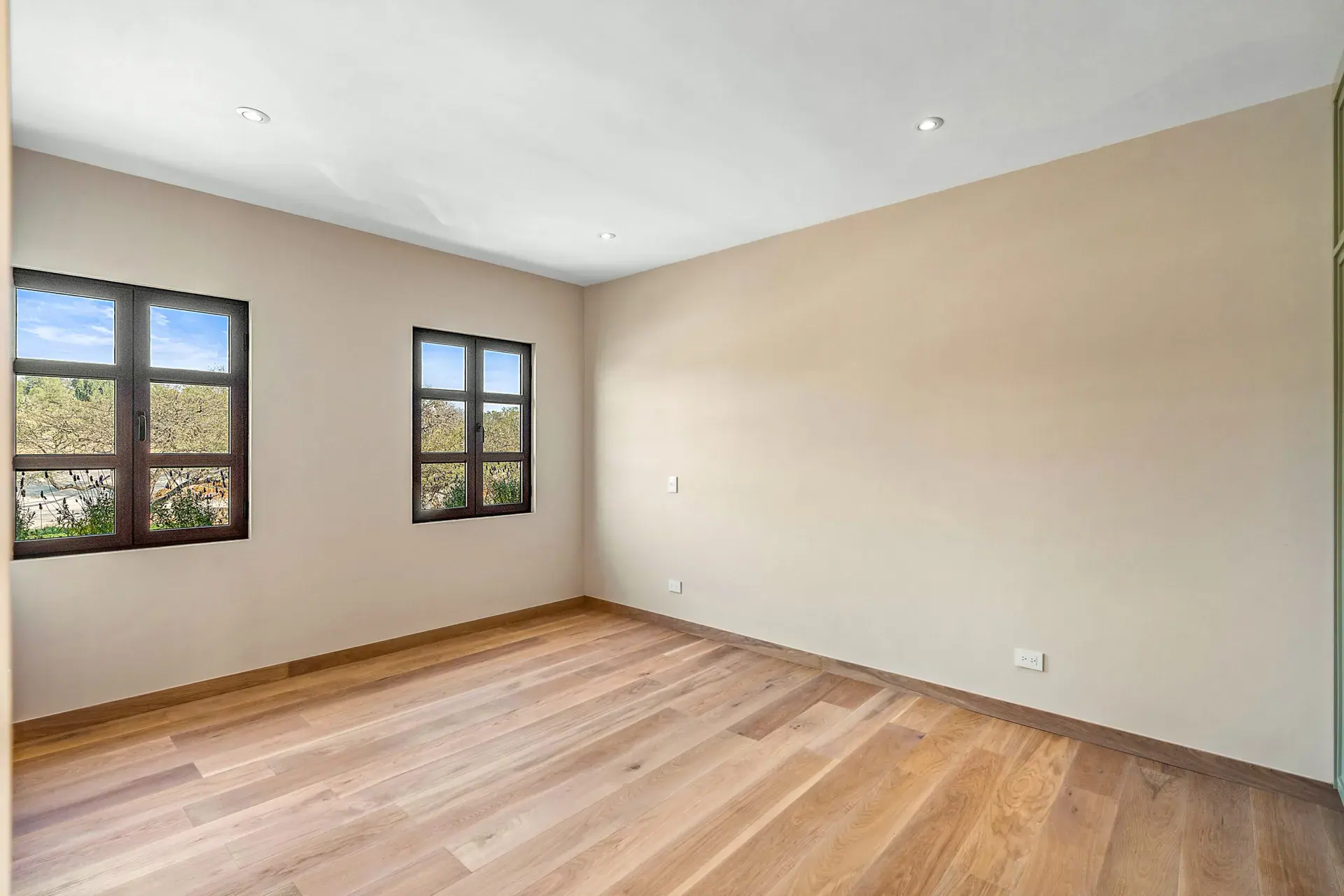 Casa Lavanda, empty bedroom with two windows looking onto trees, San Miguel de Allende