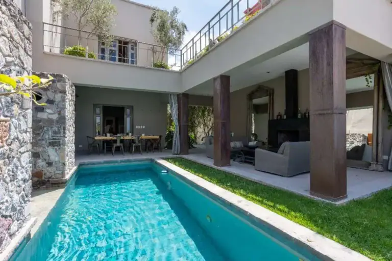 Casa Lily, lap pool in the courtyard beside a covered terrace and a lawn, San Miguel de Allende