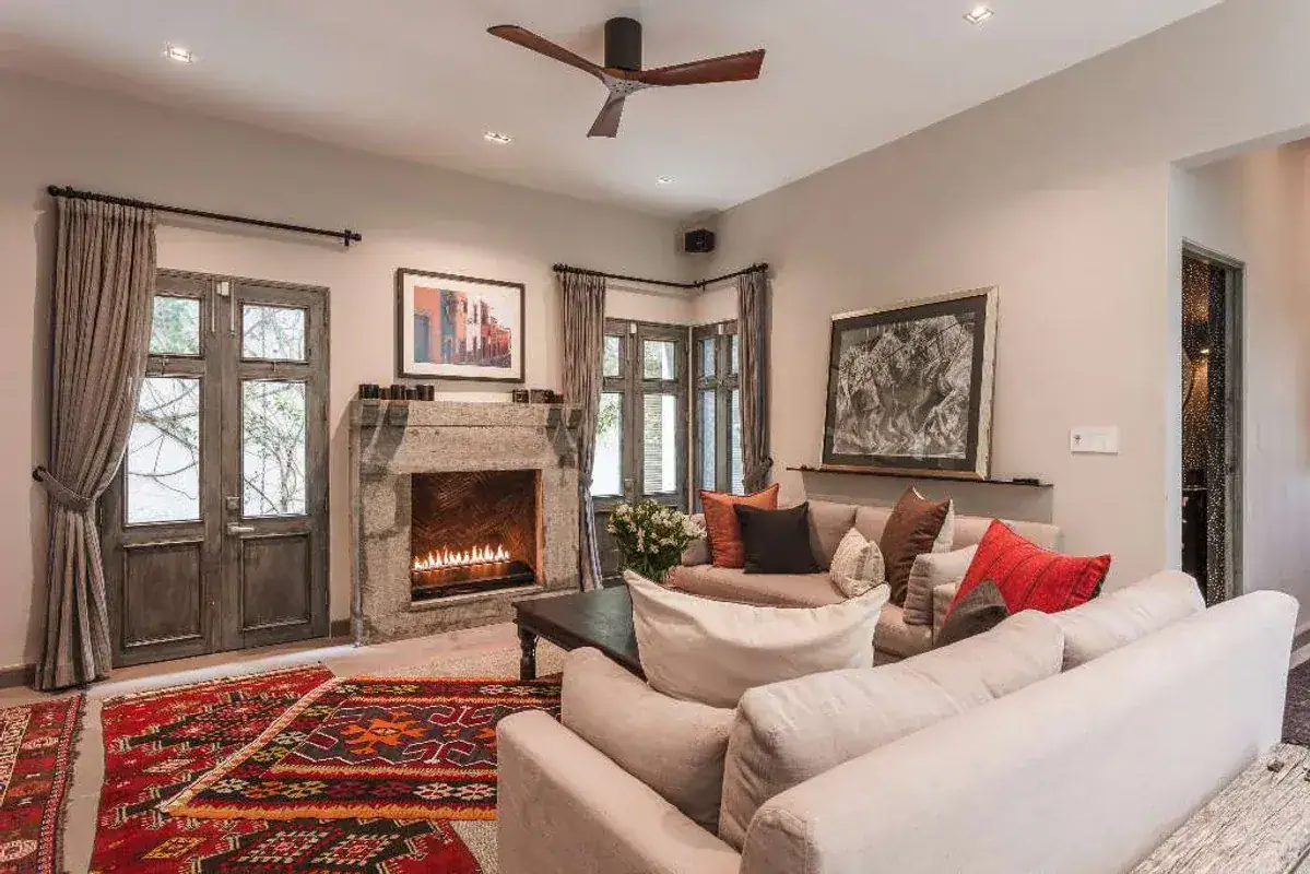 Casa Lily, living room with a stone fireplace, a red kilim rug and double doors, San Miguel de Allende