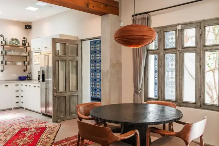 Casa Lily, dining table with wood chairs and a copper pendant beside the kitchen, San Miguel de Allende