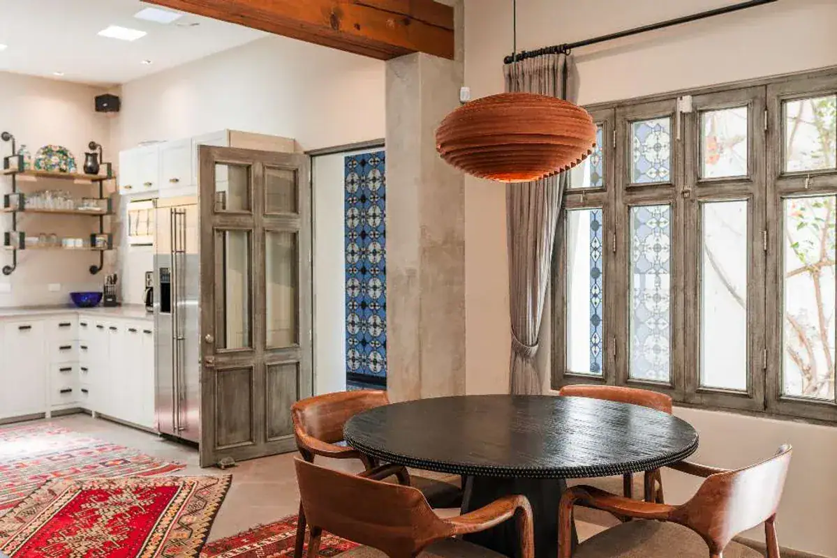 Casa Lily, dining table with wood chairs and a copper pendant beside the kitchen, San Miguel de Allende