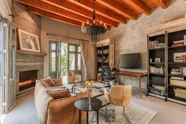Casa Lily, study with a gas fireplace, black bookshelves and a wood beam ceiling, San Miguel de Allende